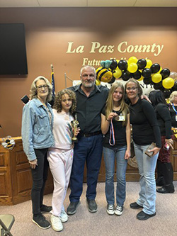 Two students posing with family members