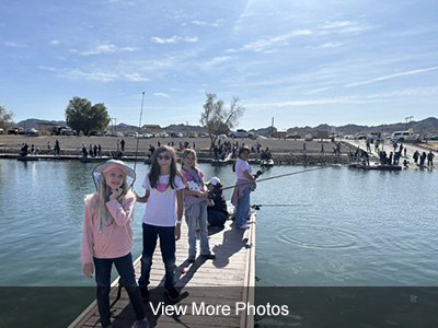 Students with fishing poles standing on a pier - View more photos
